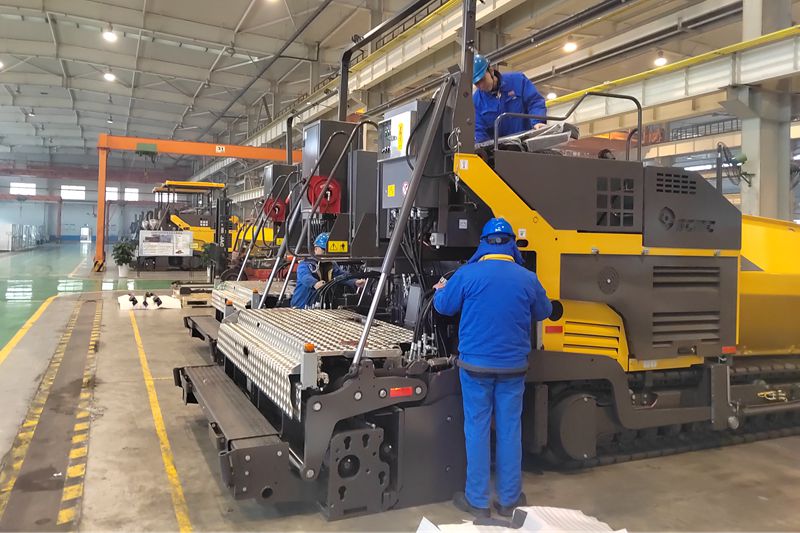 1、工人們抓緊時間總裝即將出口的瀝青混凝土攤鋪機.jpg